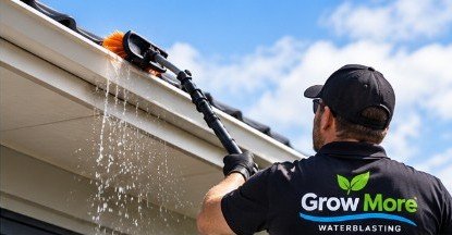 Cleaning a gutter with a brush, water running out